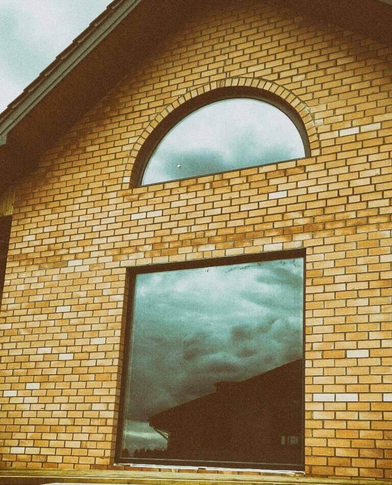 Арочные окна в кирпичном доме в Зацени