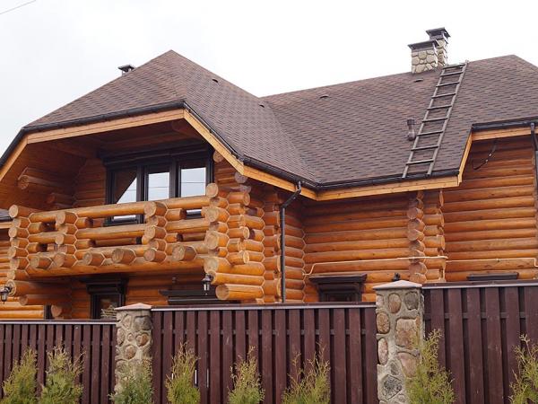 Деревянные окна в коттедже из бревна с наличниками общий вид